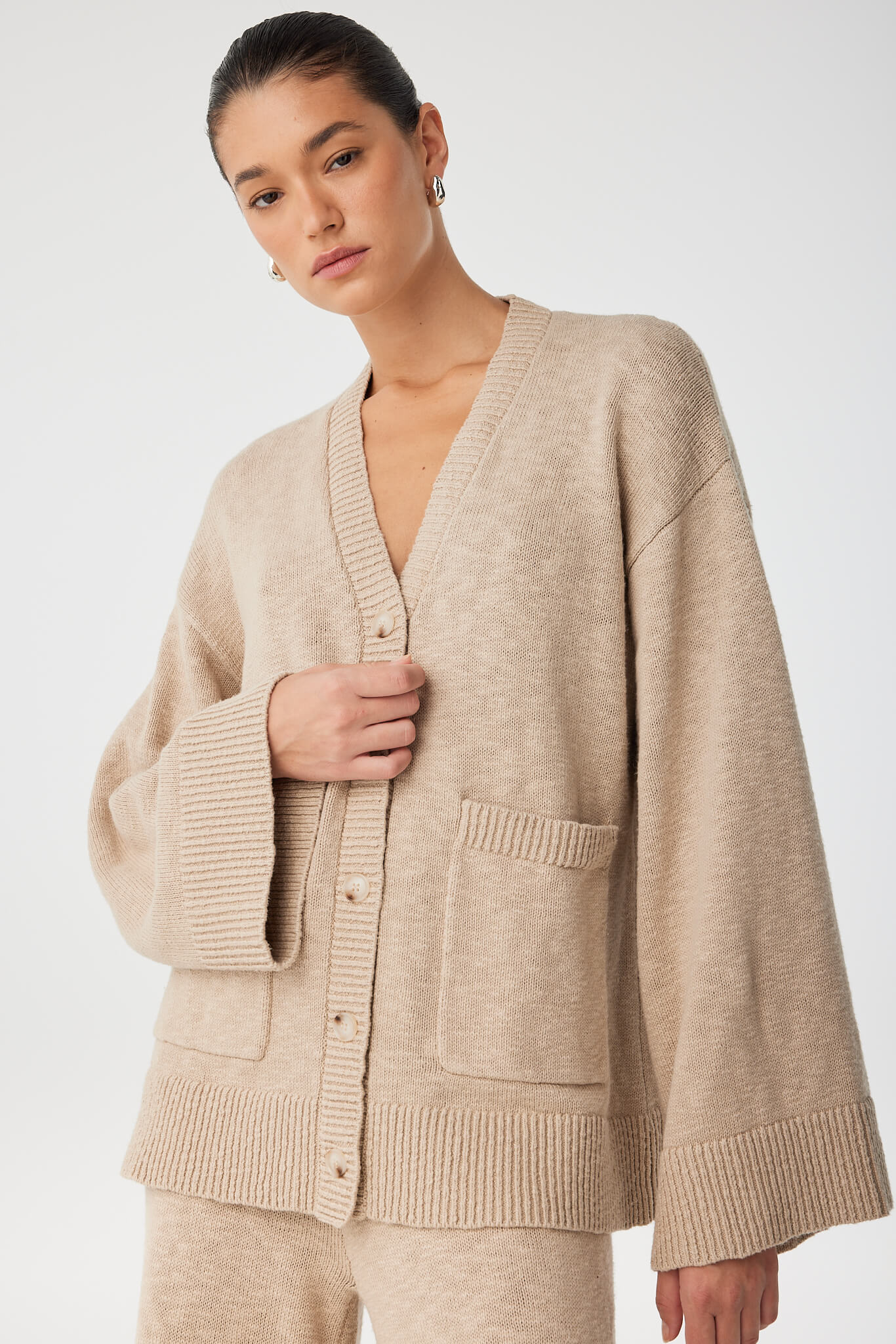 Close-up of slub knit texture and patch pocket detail in organic cotton cardigan.