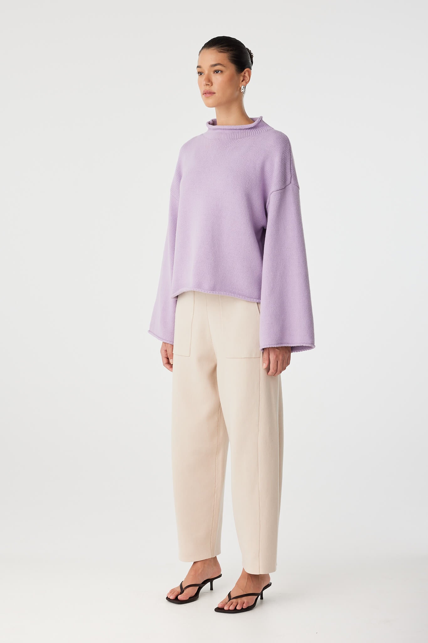 Side angle of relaxed funnel neck sweater showing sleeve width and casual drape.