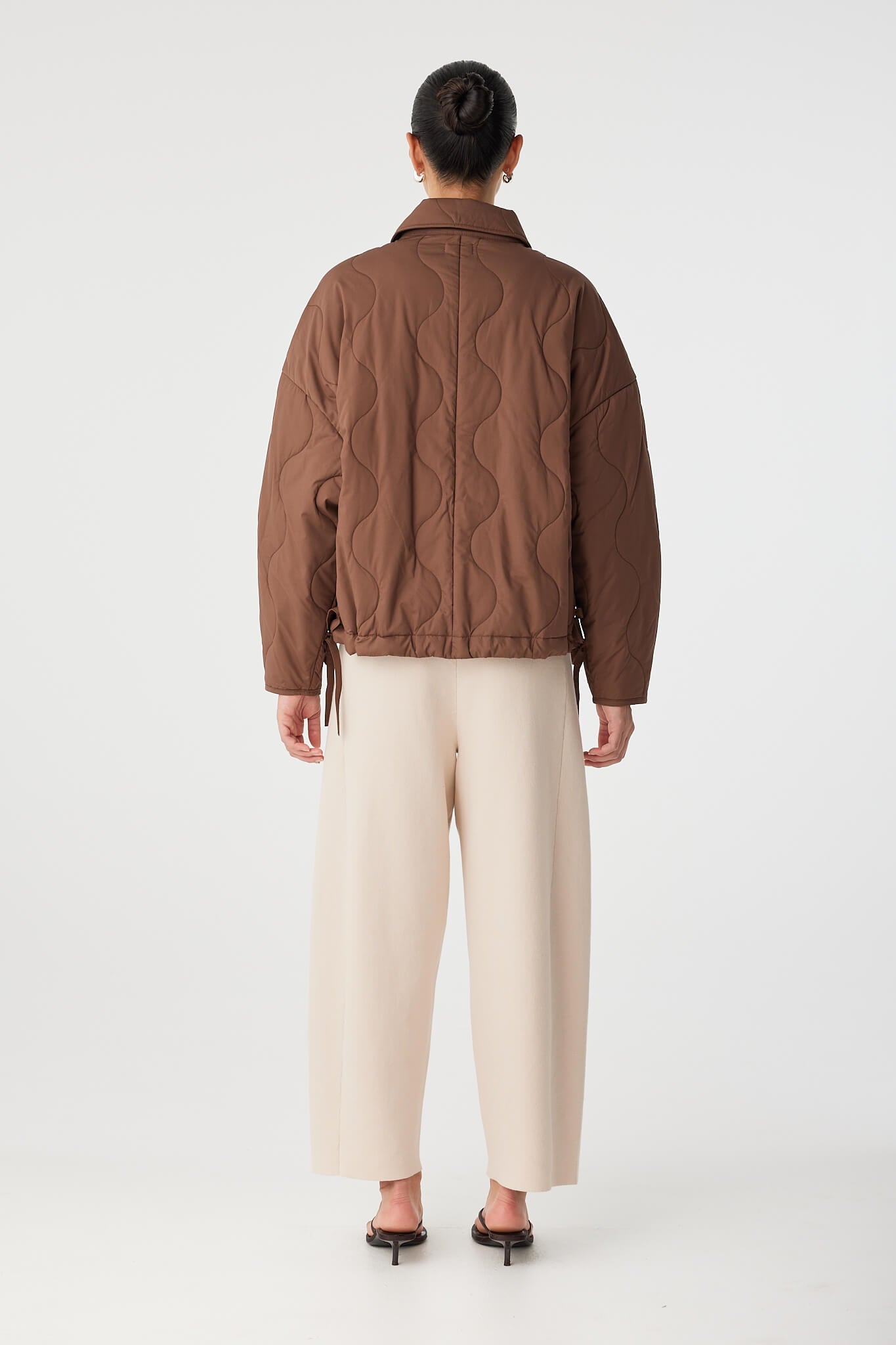Back view of quilted cotton jacket with dropped shoulders and soft structure.