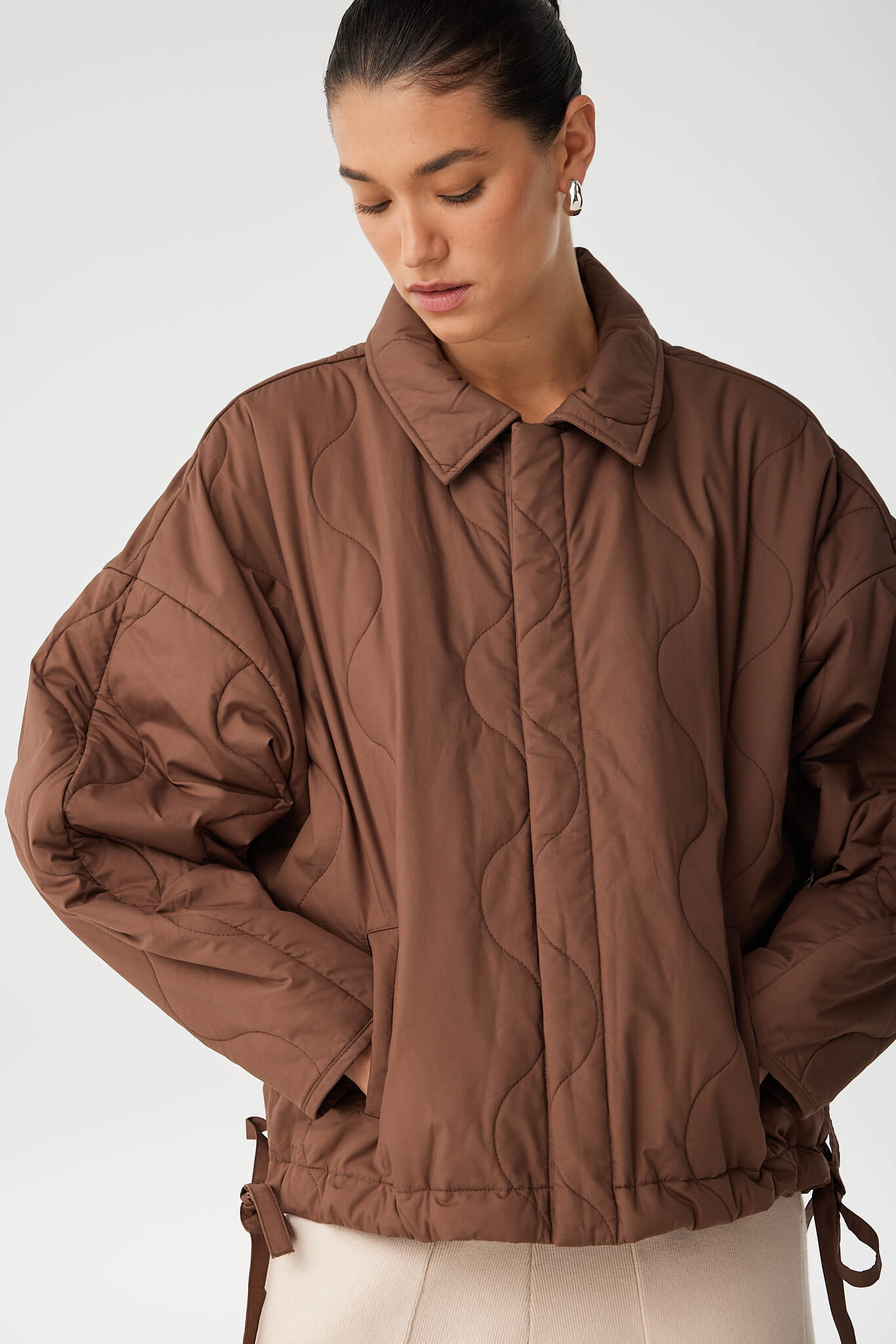 Subtle cocoon sleeve shape and soft cotton texture in espresso quilted jacket.