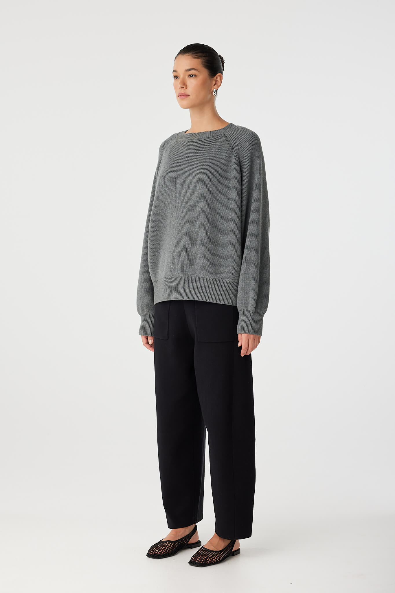 Side angle of slouchy sweater with raglan sleeve detail and ribbed neckline.