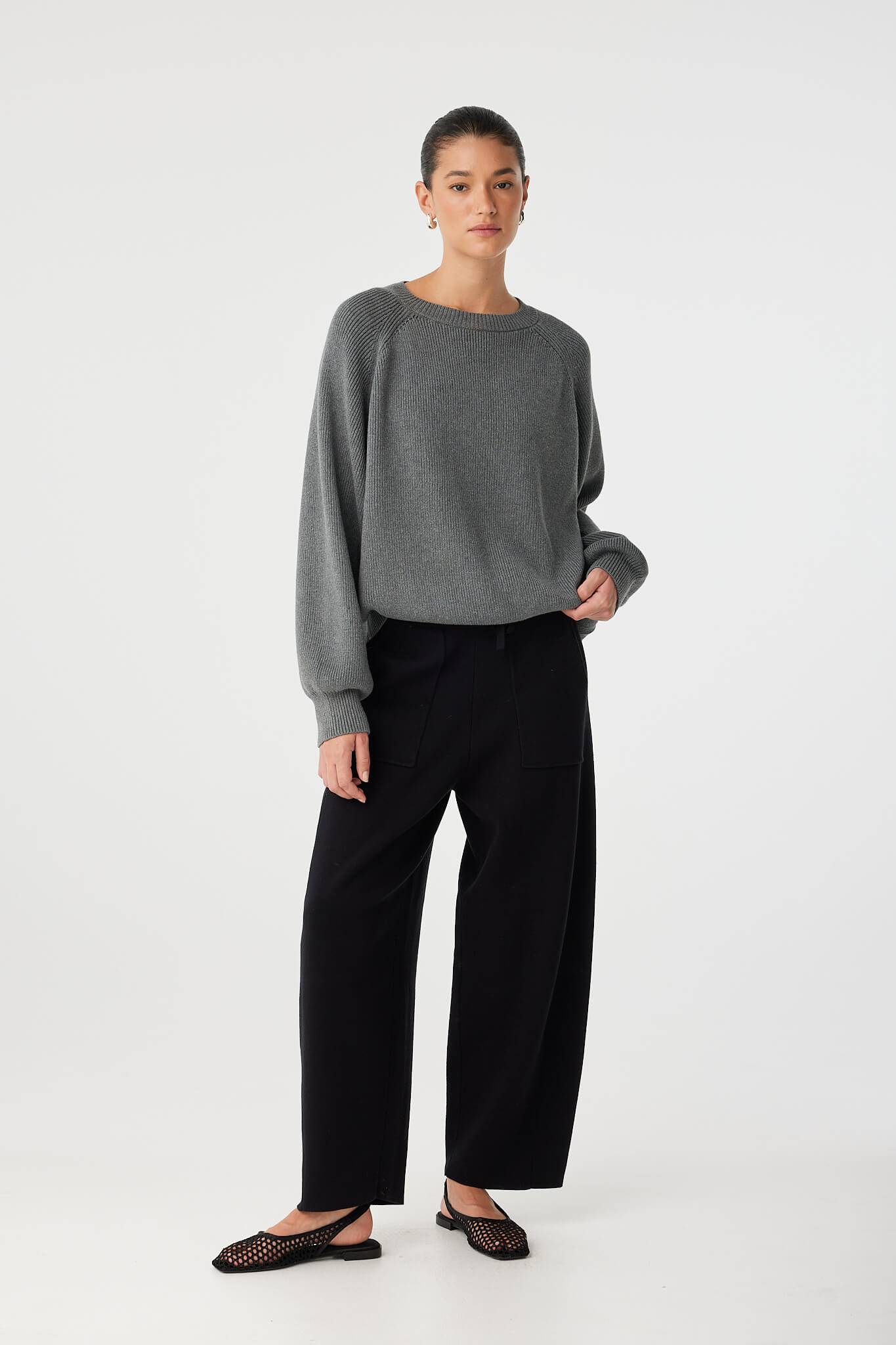 Relaxed moment in black organic cotton knit pants, ideal for layered styling.