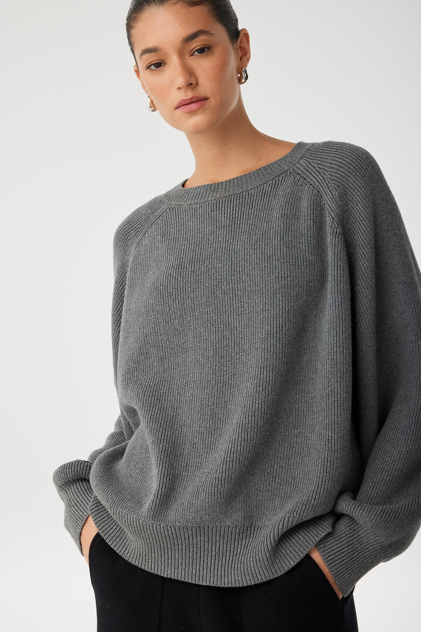 Close-up of ribbed texture at neckline and soft stretch in dark grey marle cotton knit.
