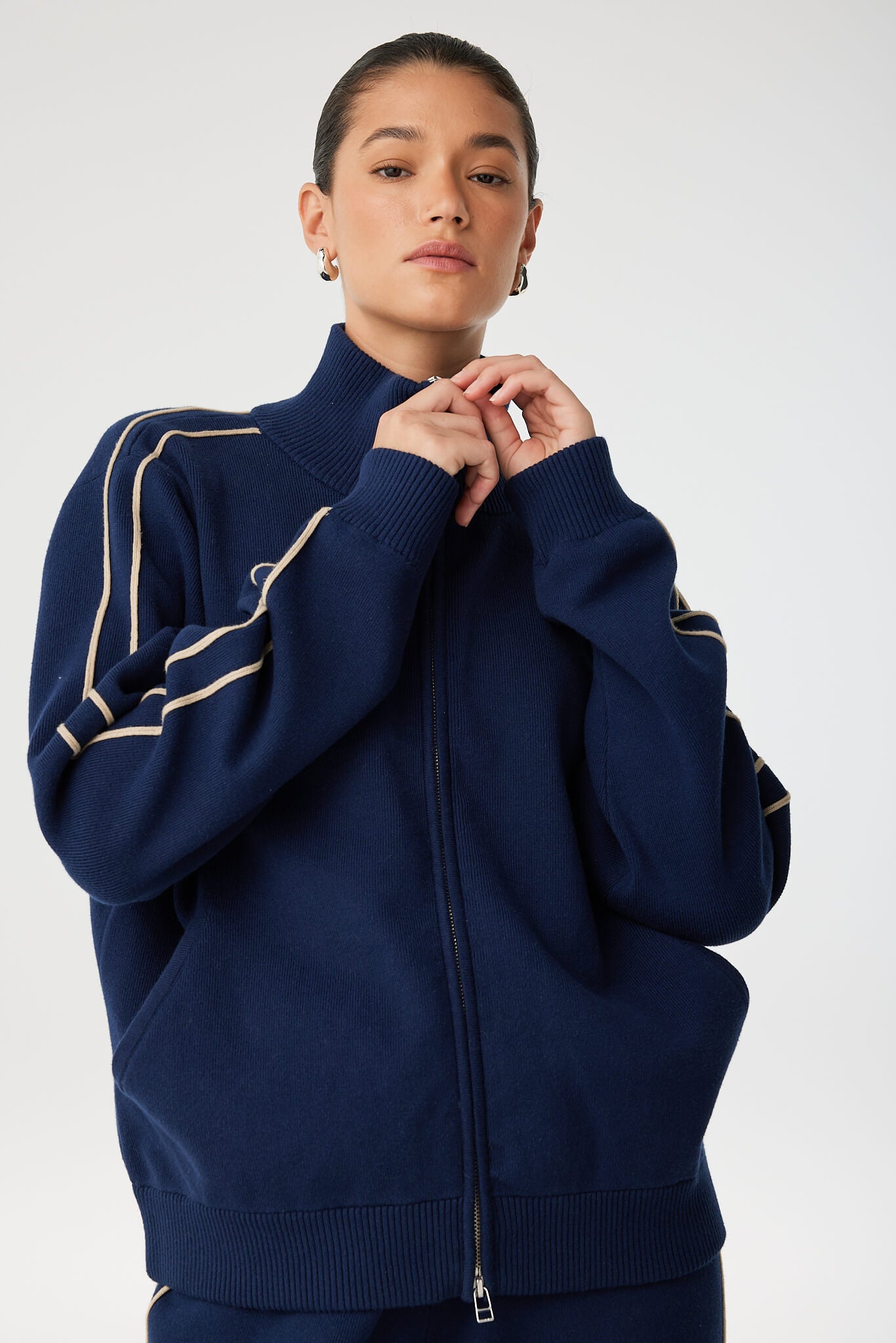 Detail of ribbed funnel collar and double stripe sleeve in organic cotton stretch jacket.