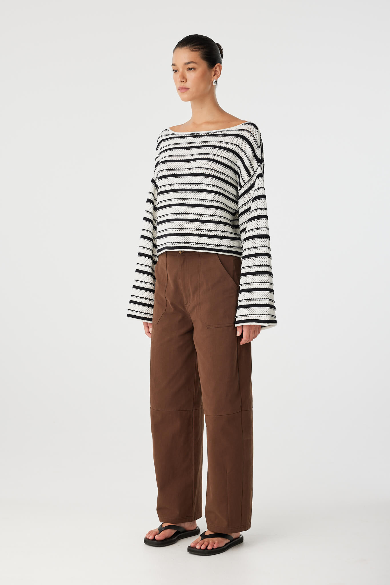 Side view of striped organic cotton sweater showing wide sleeve silhouette and cropped length.