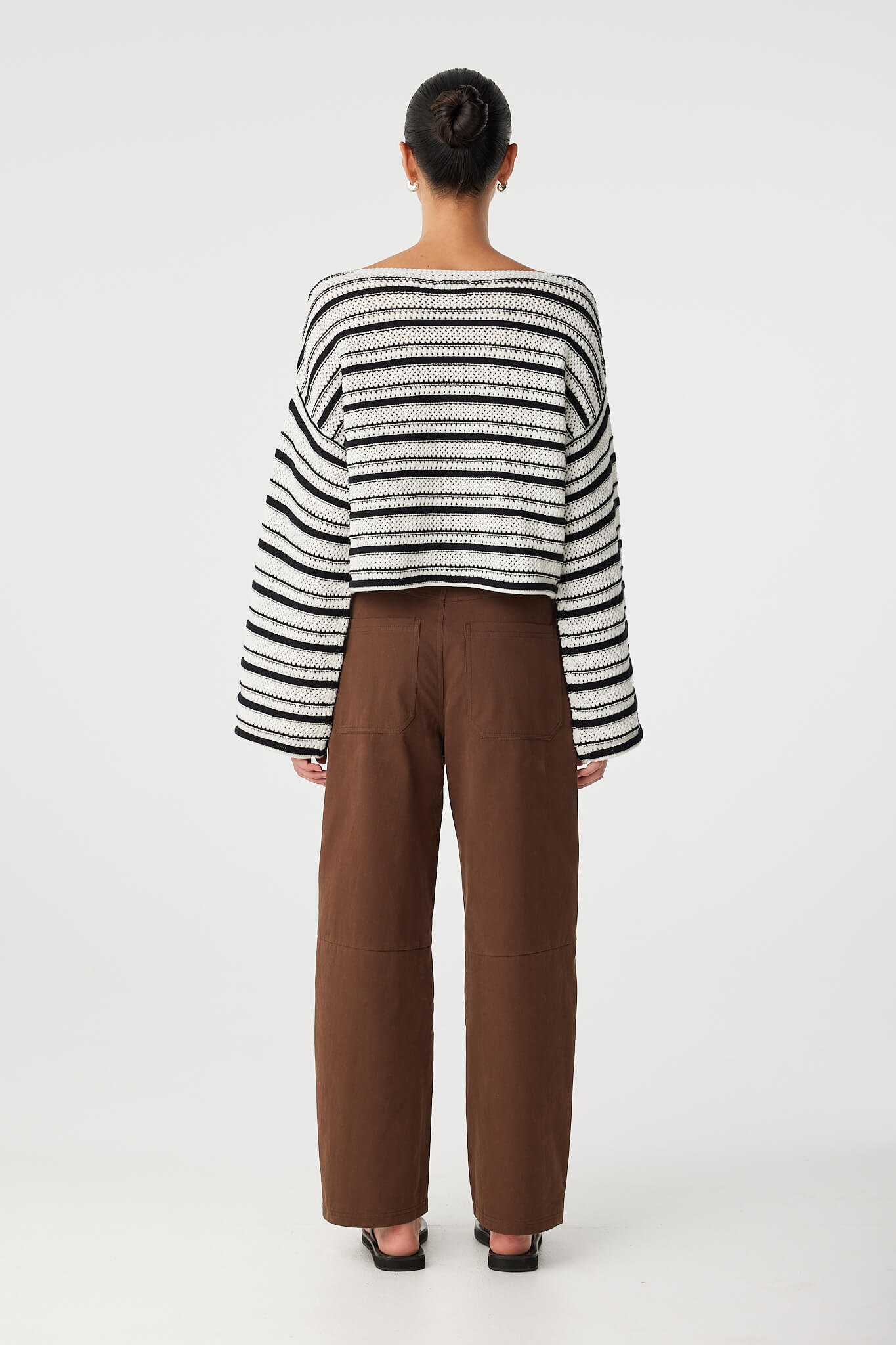 Back view of black and cream stripe sweater with loose fit and textured crochet knit.