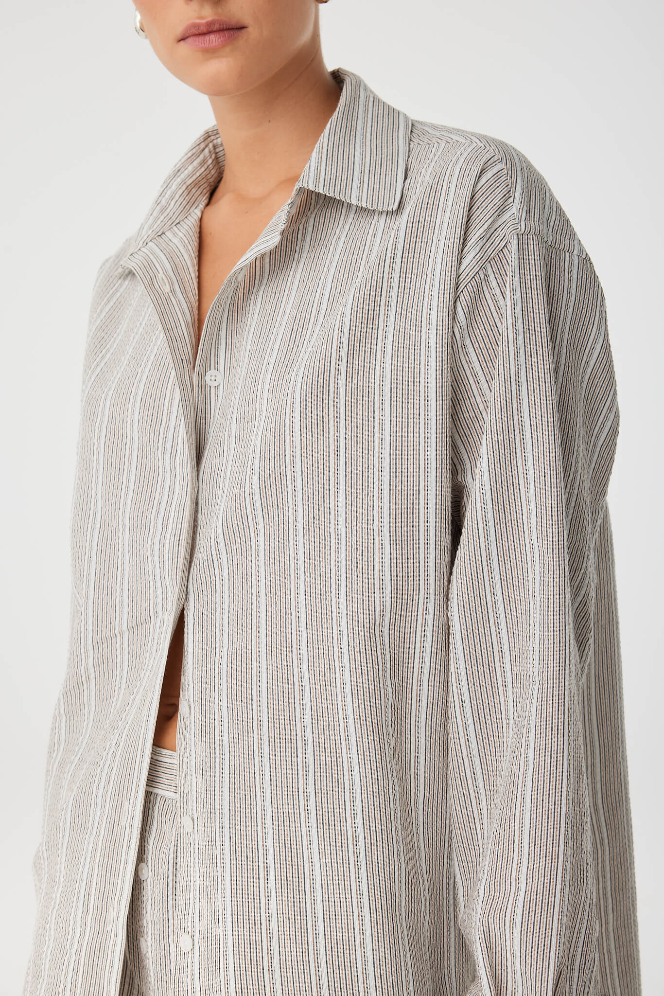 Detail of shirt collar and fine textured stripe cotton for breathable everyday wear.