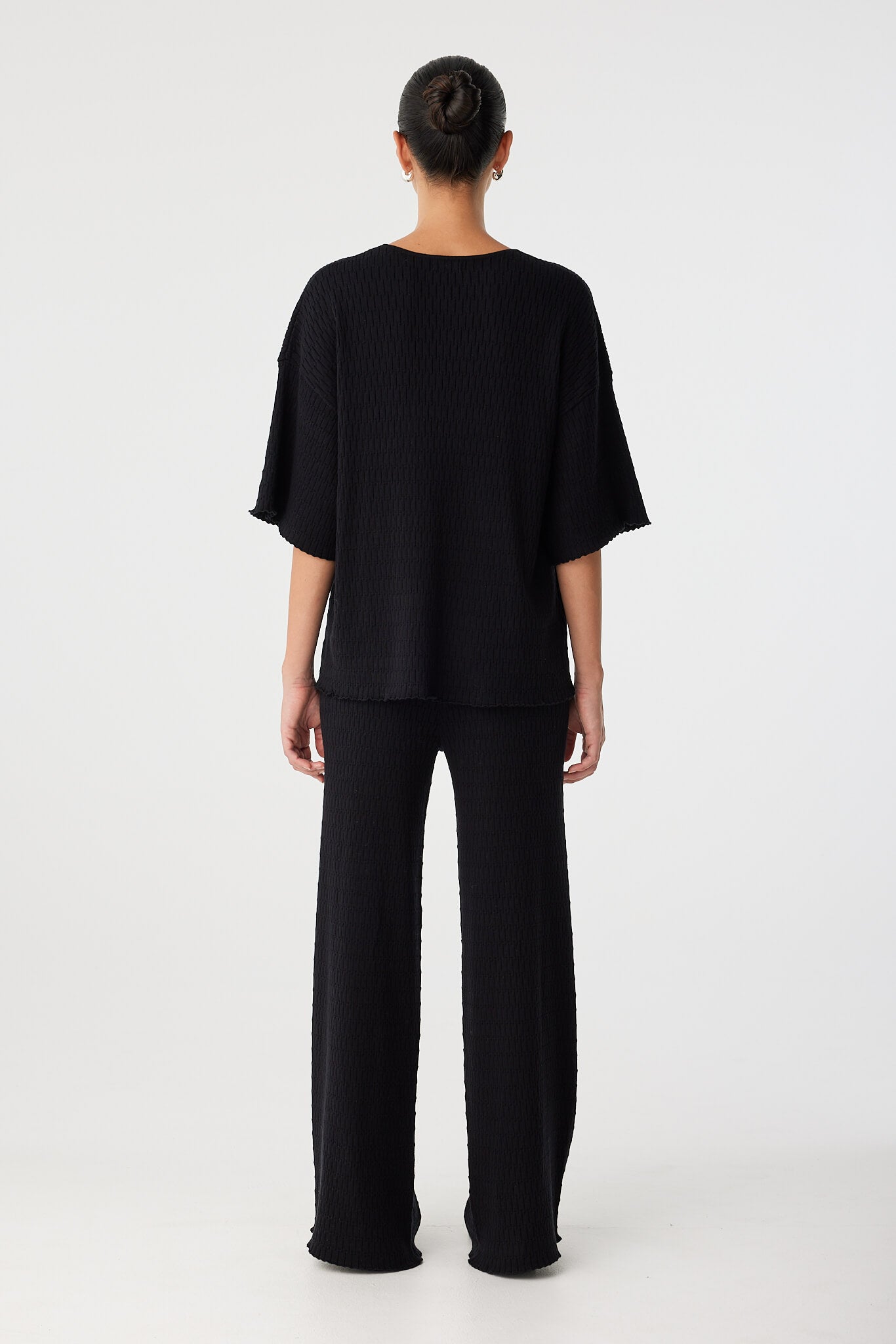 Back view of Jude T-shirt in black textured knit showing boxy, oversized silhouette.