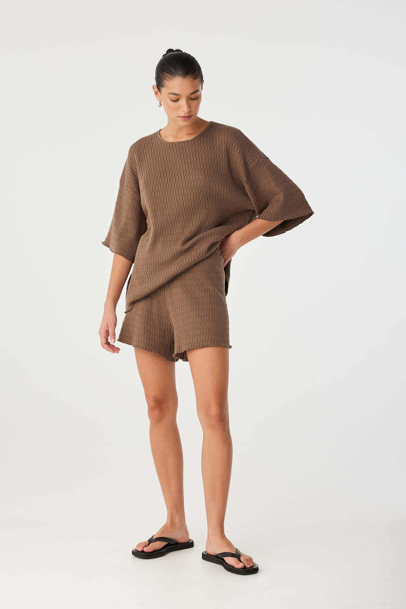 Model styled in head-to-toe textured knit set, combining the Jude Tee and Shorts in cacao, versatile for slow days or travel layering.