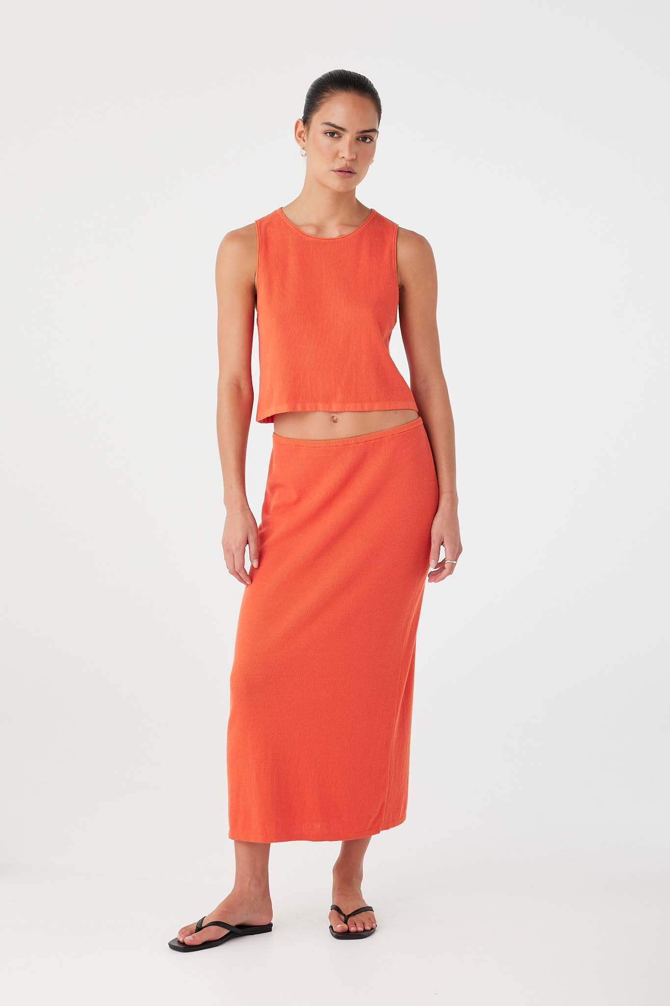 Model wearing mandarin knit tank top styled with tonal skirt, designed for warm-weather ease.