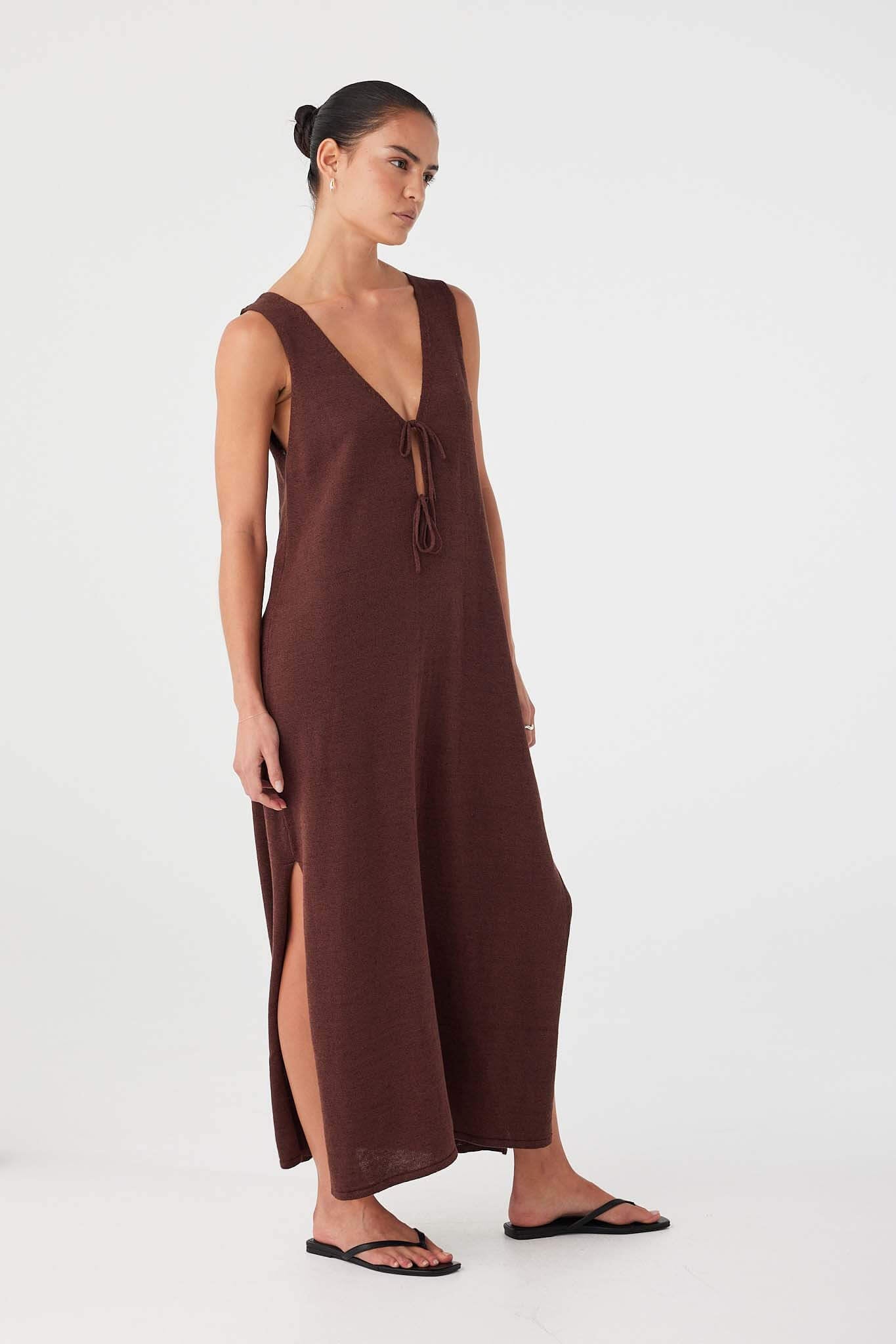 Model wears chocolate reversible maxi dress with V-neck tie front. Deep side slits add ease and movement.