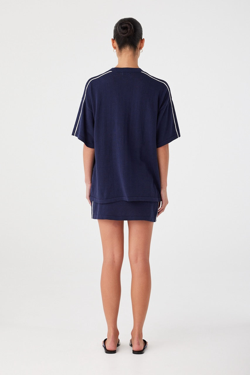 Back view of oversized navy tee with contrast shoulder stripe. Loose silhouette in breathable linen cotton knit.