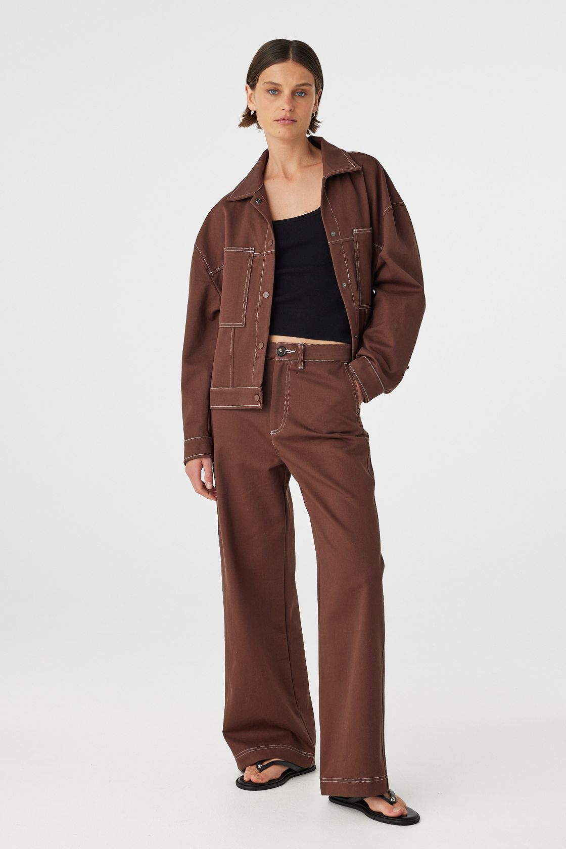 Full body front view of brown jacket styled with matching set