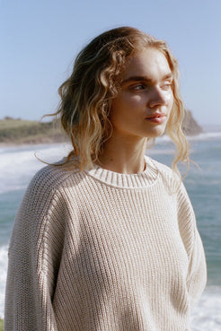 Lifestyle close-up of cream sweater worn outdoors