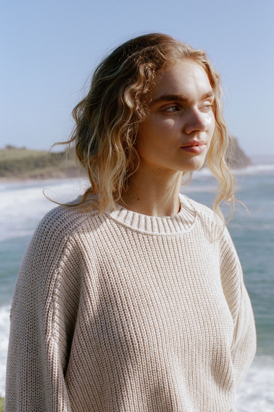 Lifestyle close-up of cream sweater worn outdoors