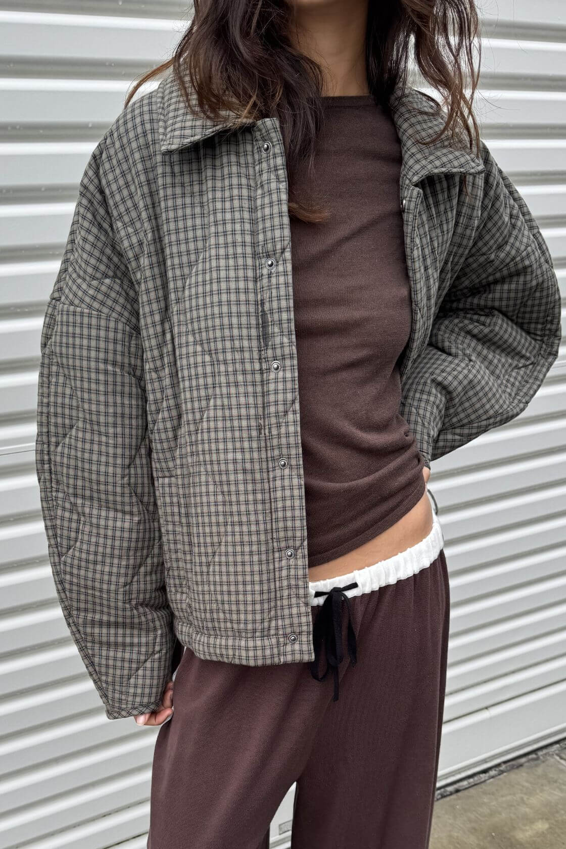 Detailed front view of the Matteo Jacket in Olive & Teal Check, highlighting the snap button front, quilted texture, subtle check pattern, oversized sleeve and relaxed cropped fit.