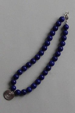 Blue chalcedony gemstone necklace shown in a gentle curve, highlighting the silver Eddy Swirl pendant on a neutral background.