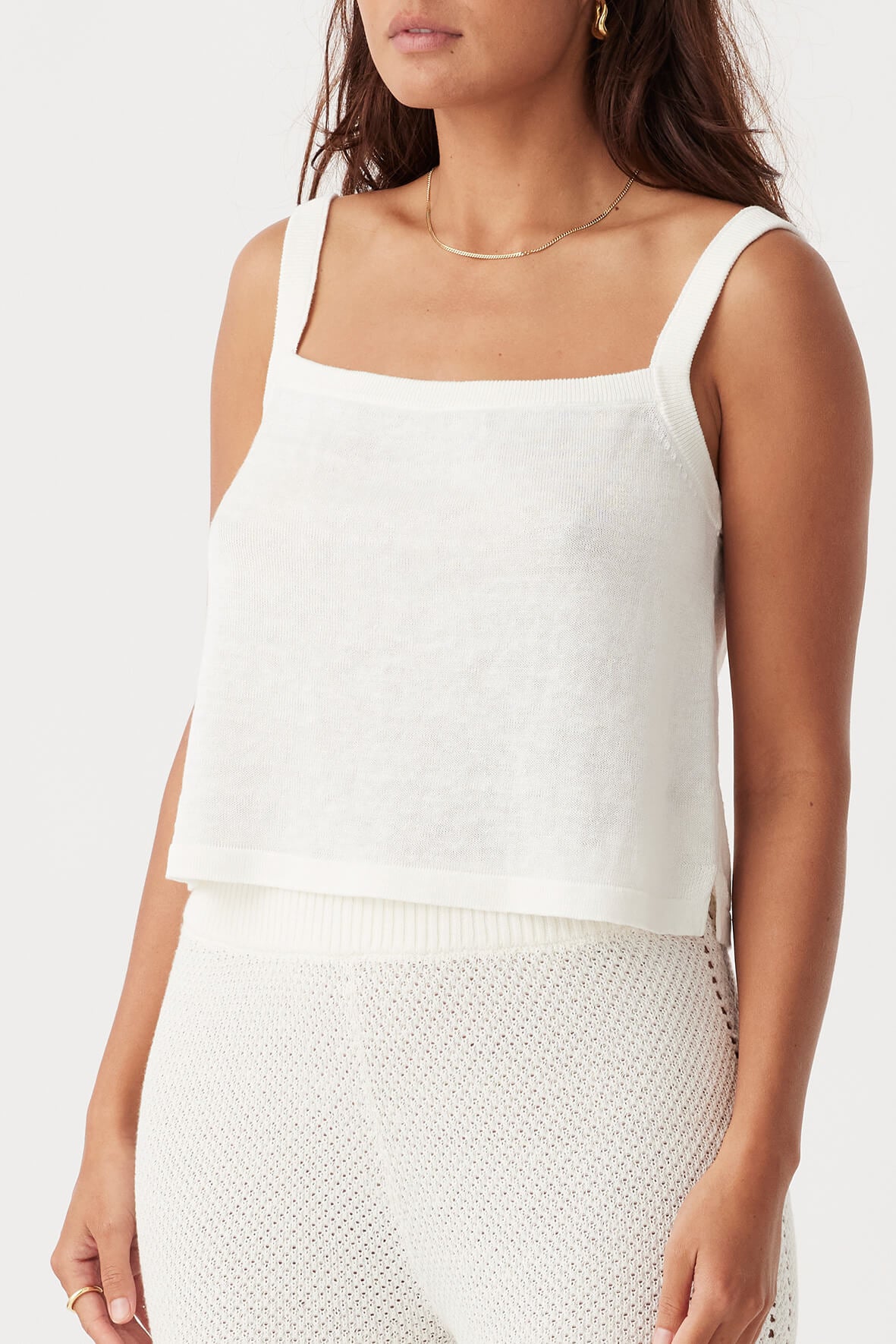 Angled front view of the Brie Tank in Cream, highlighting its subtle side splits and lightweight fabric.