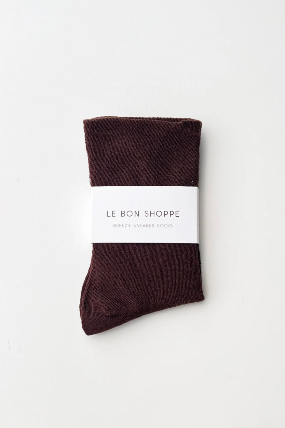 Pair of brown socks with a white label on a light gray background