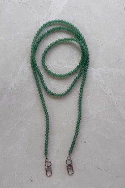 Hand-strung green aventurine crystal beaded phone carrier with clear loop attachment, coiled to show soft green tones and natural variations.