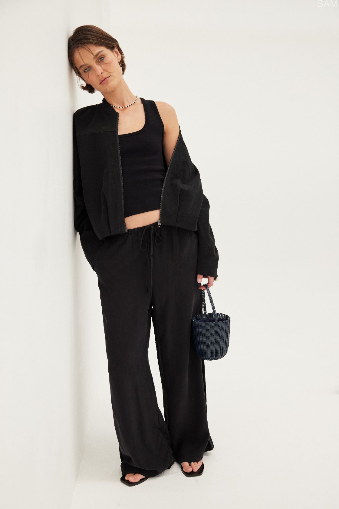 Outfit view of Rae Pant black, cupro–rayon straight-leg pants with elastic waist styled with black top.