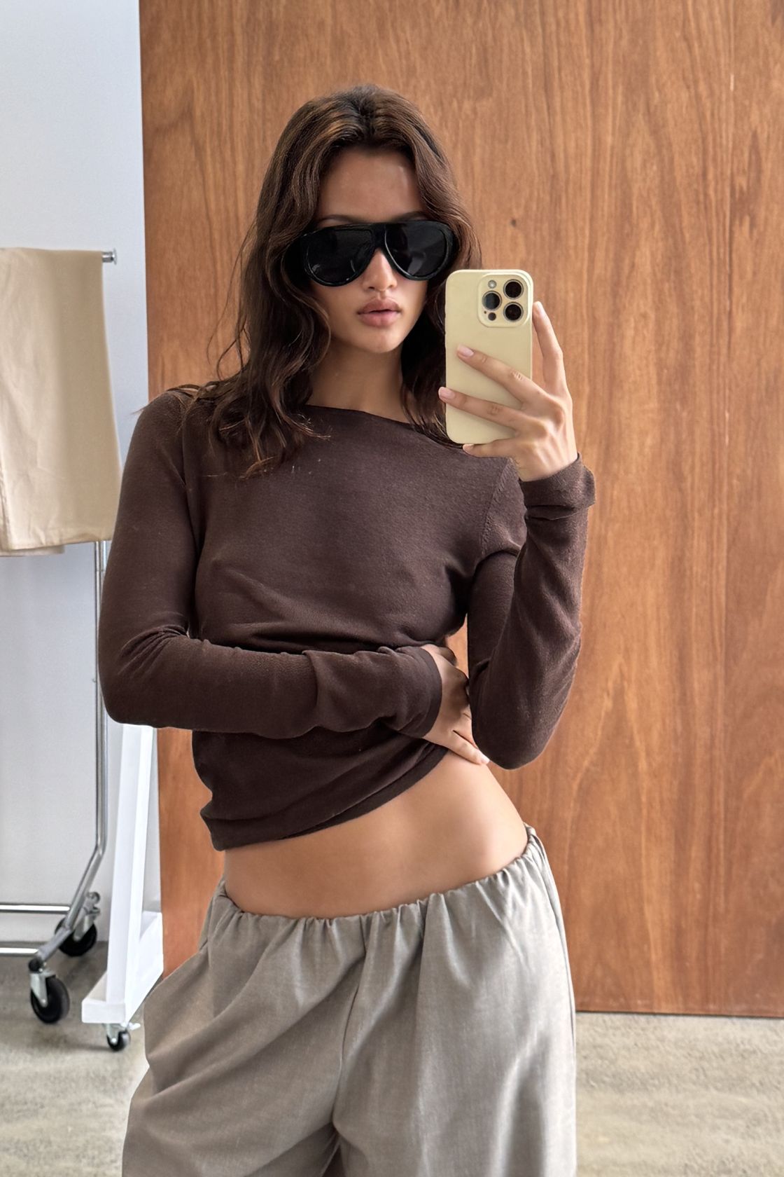 Close-up of the Aston Long Sleeve Top in Espresso, featuring a sleek fitted silhouette, wide boat neckline and soft stretch fabrication, paired with the Annika Pant in Taupe & Blue Pinstripe.