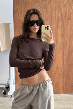 Close-up of the Aston Long Sleeve Top in Espresso, featuring a sleek fitted silhouette, wide boat neckline and soft stretch fabrication, paired with the Annika Pant in Taupe & Blue Pinstripe.