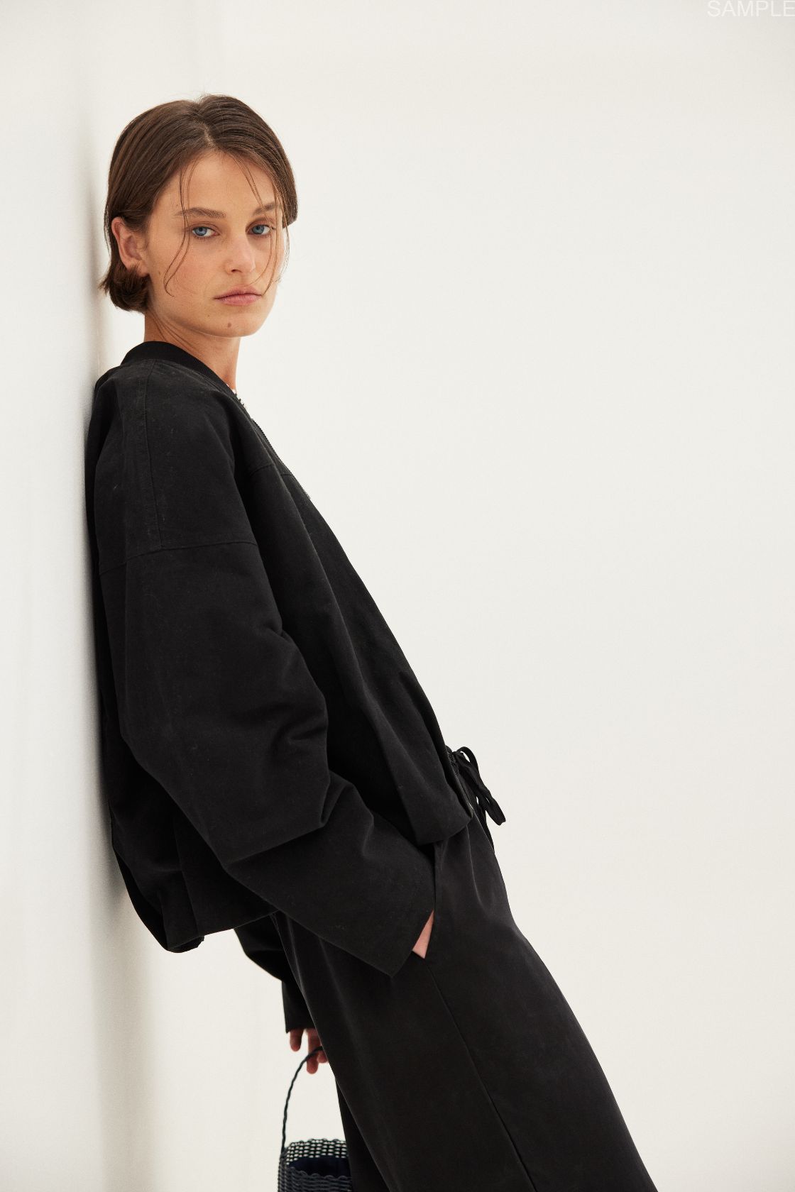 Lifestyle angle: Rae Pant black, cupro–rayon drapey pants showing movement and soft fall.