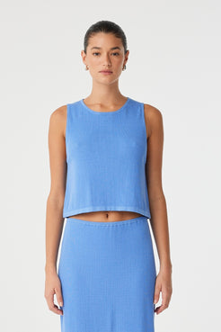 Model wears ribbed knit tank in pacific blue with flared hem, styled with matching skirt in lightweight cotton–hemp blend.