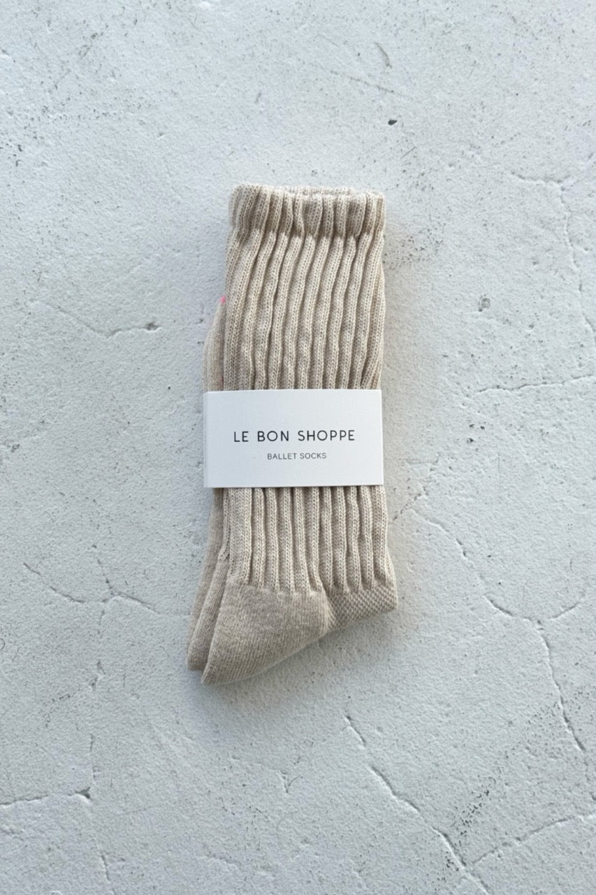 Pair of oatmeal socks with a label on a light gray background