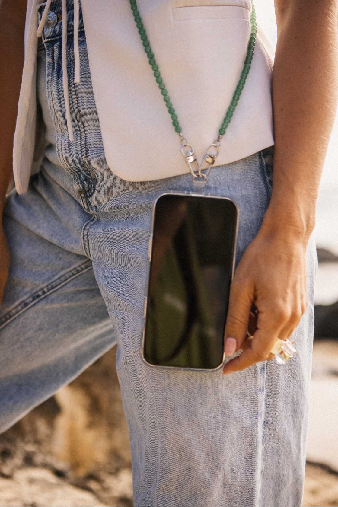Model wearing a green aventurine crystal beaded phone carrier crossbody over a neutral outfit for hands-free everyday ease.