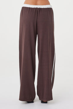 Close-up back view of the Netta Pant in espresso featuring a soft organic cotton knit texture, relaxed wide-leg silhouette and contrast cream side stripe detailing