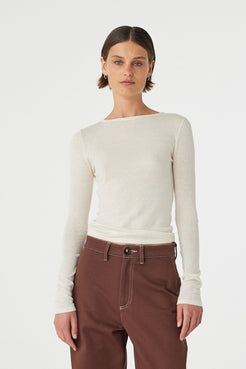 Model wearing Aston Long Sleeve Top in cream, semi-sheer cotton–linen knit with boat neckline and slim fit, front view.