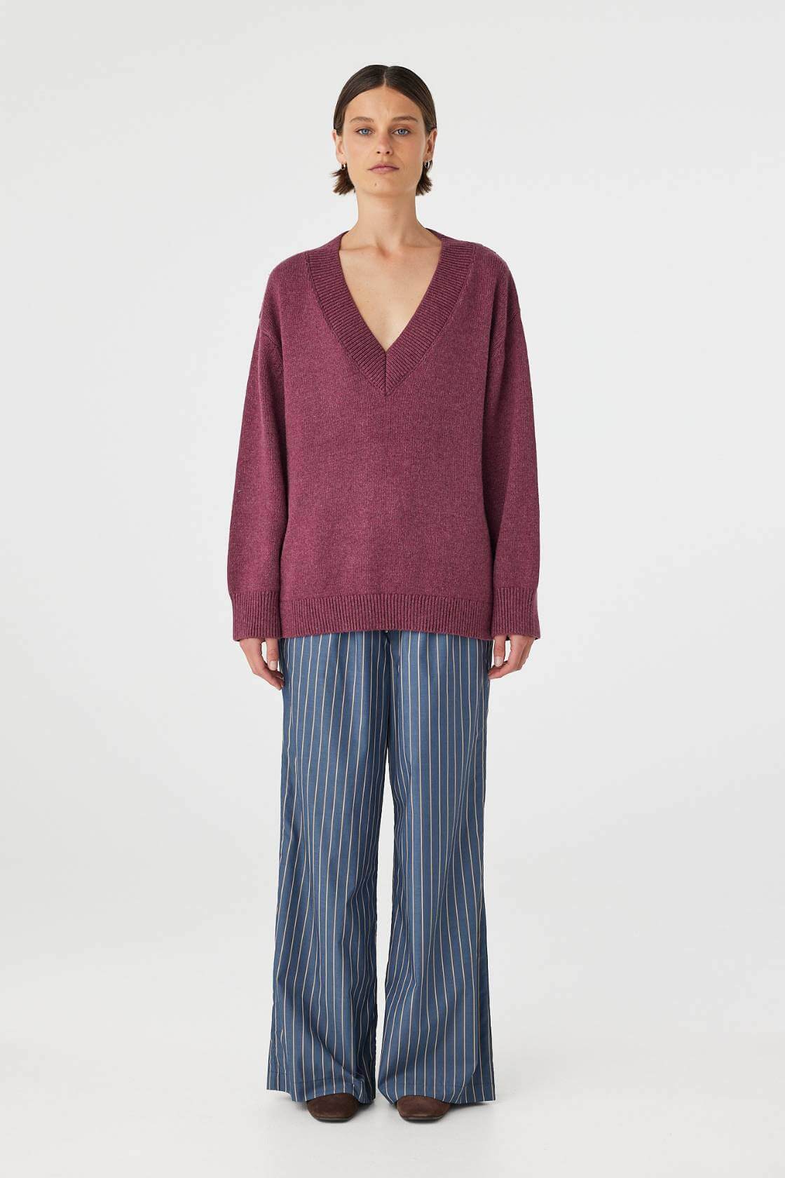 Full body front view of merlot sweater paired with blue pants