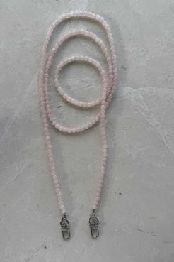 Hand-strung rose quartz crystal beaded phone carrier with clear loop attachment, coiled to show soft blush tones and natural variations.
