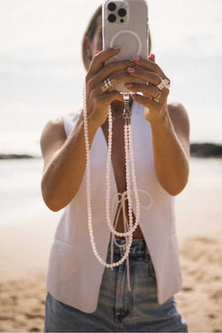 Model wearing a rose quartz crystal beaded phone carrier crossbody over a neutral outfit for hands-free everyday ease.