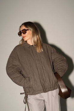 Espresso check jacket with relaxed, boxy fit styled with neutral pants