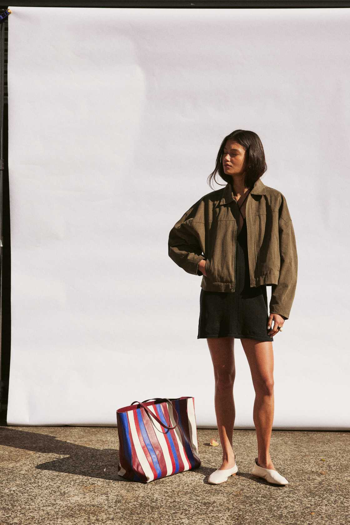 Full-body studio shot of khaki cropped jacket and mini skirt set, relaxed fit for walking and travel layers 