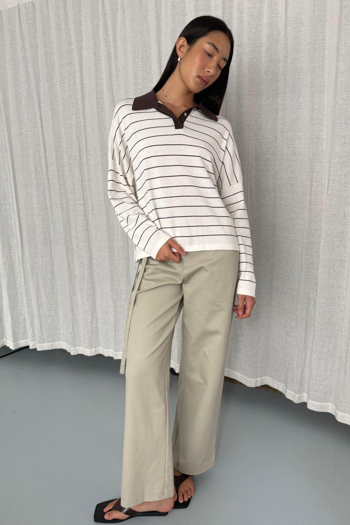 Model wearing the Zia tie knit in cream and espresso stripe in a studio setting