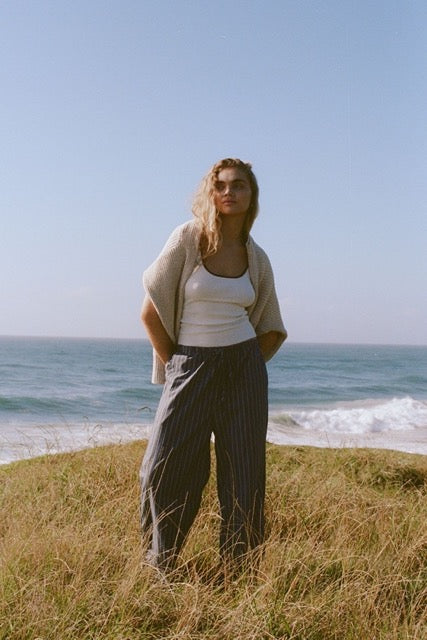 Kaya Tank in cream and merlot worn outdoors by the ocean with Rae pants in muted blue stripe