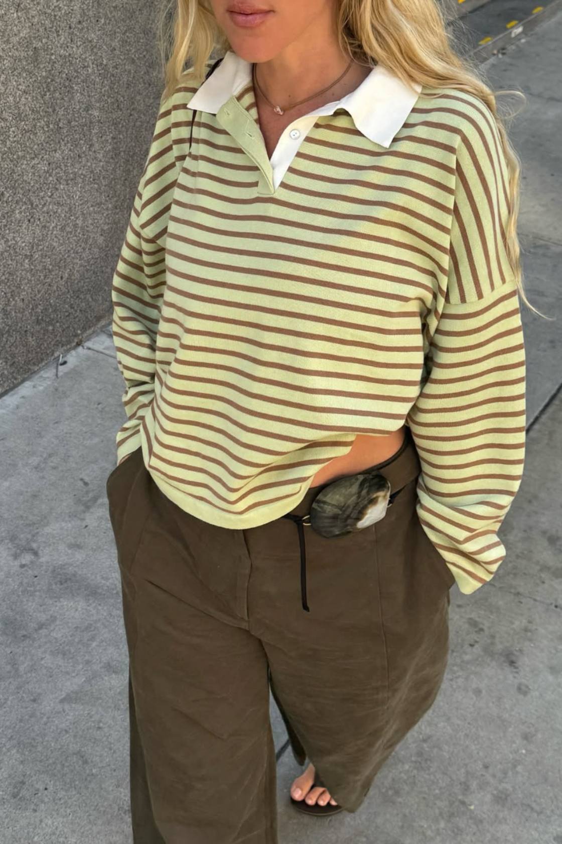 Celery and pecan striped knit top styled with khaki pants outdoors on concrete 