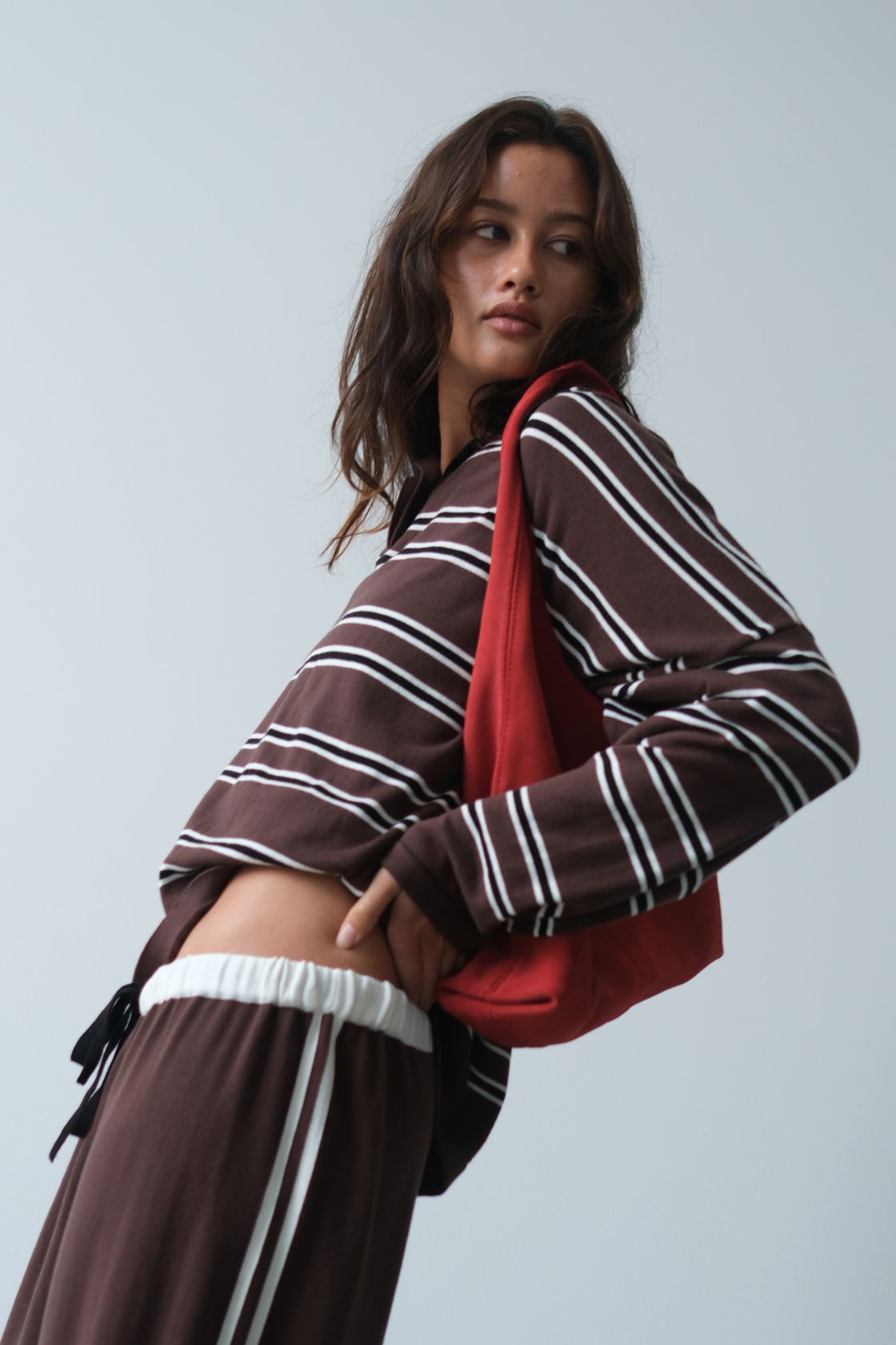 Close-up side profile of the Rayne Jersey in Espresso, Cream & Black Stripe, showcasing the relaxed drape, collared neckline, stripe placement and coordinating drawstring waistband of the matching pants.