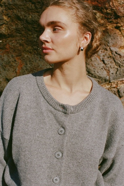 Close-up lifestyle view of grey cardigan with crew neckline and buttons