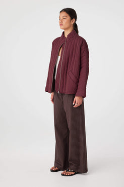 Side view of Merlot quilted zip jacket showing slouchy sleeve shape and hip-length coverage