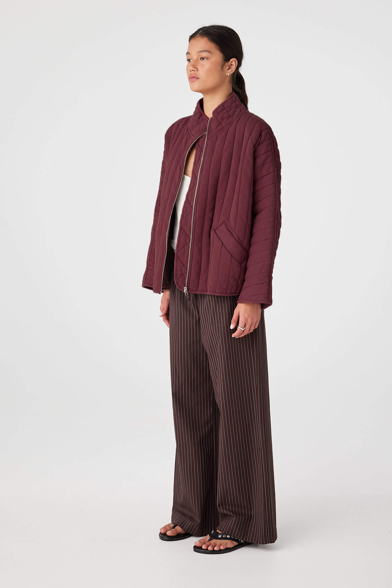 Side view of Merlot quilted zip jacket showing slouchy sleeve shape and hip-length coverage