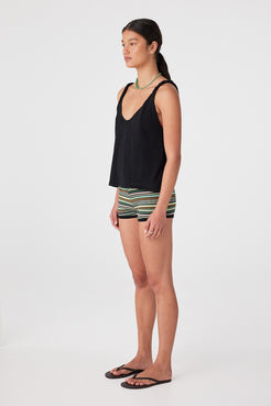 Side profile of woman in black relaxed tank showing twist strap and shaping seams