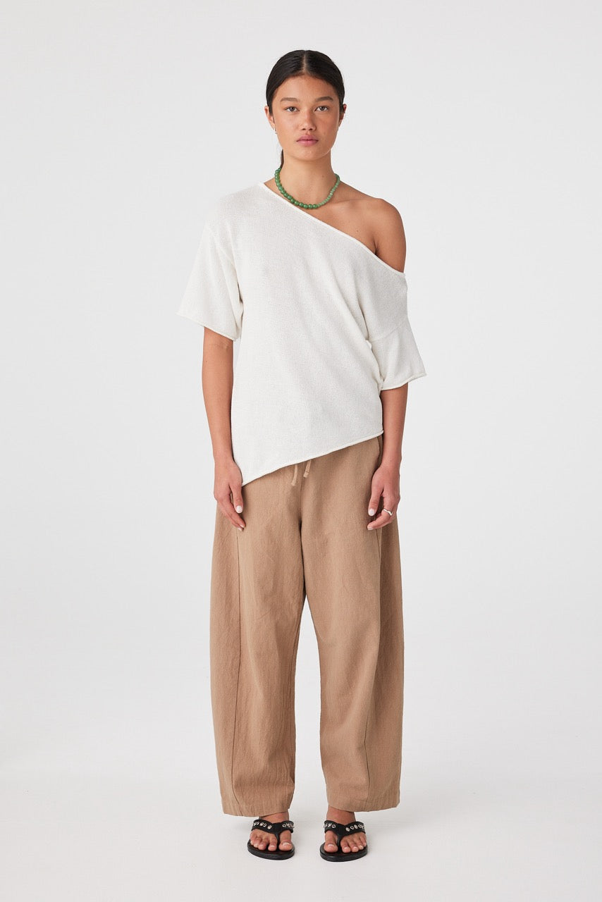 Full length front view of outfit with white off-shoulder top and pecan barrel-leg pants