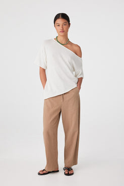Front view of model wearing pecan relaxed barrel-leg linen cotton pants with white top