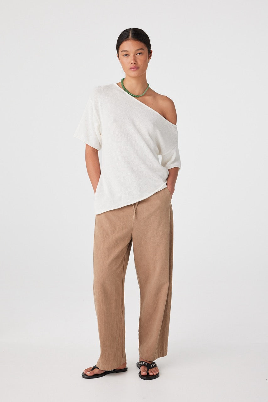 Front view of model wearing pecan relaxed barrel-leg linen cotton pants with white top