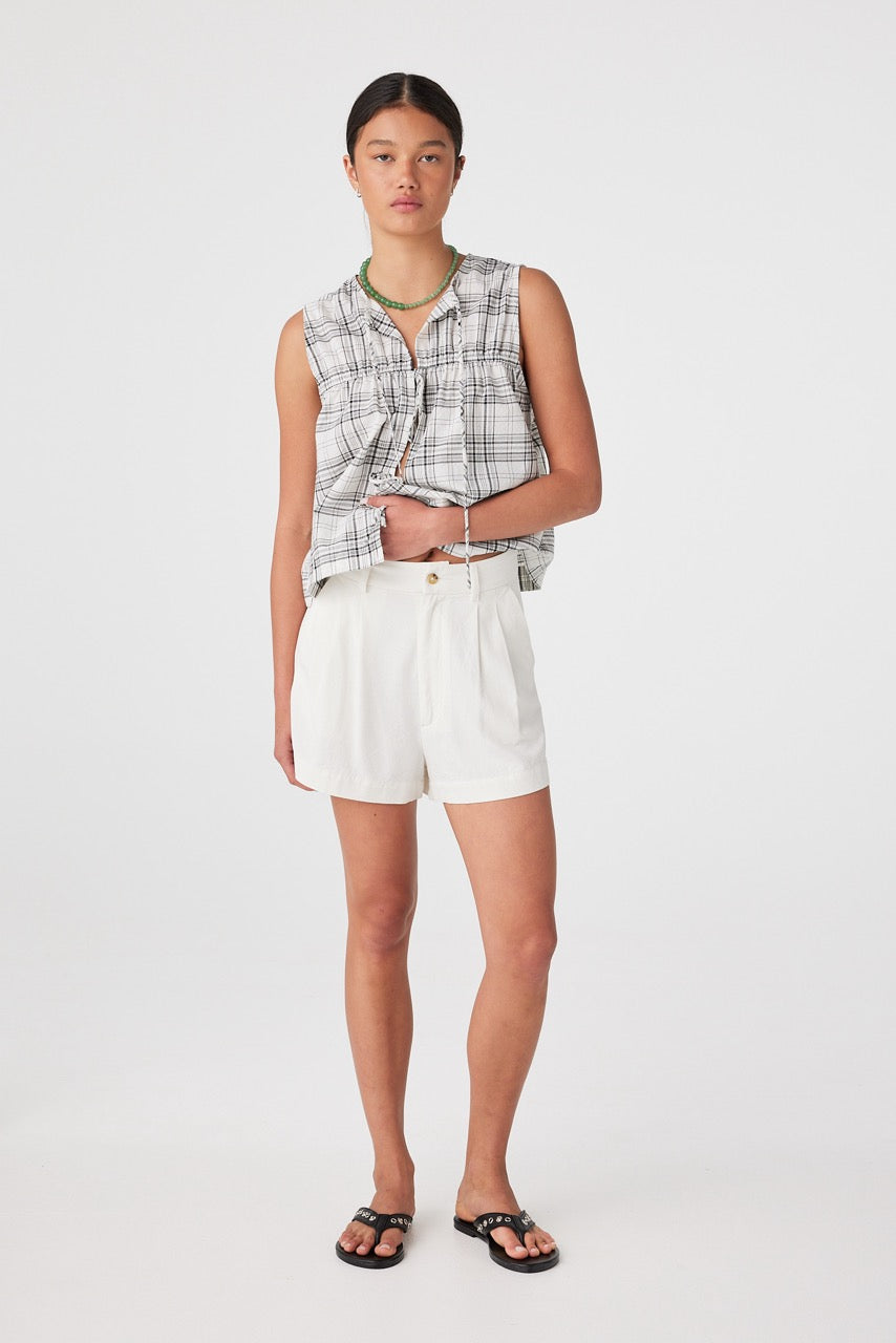 Front view of model wearing cream boxy linen cotton shorts with check sleeveless top
